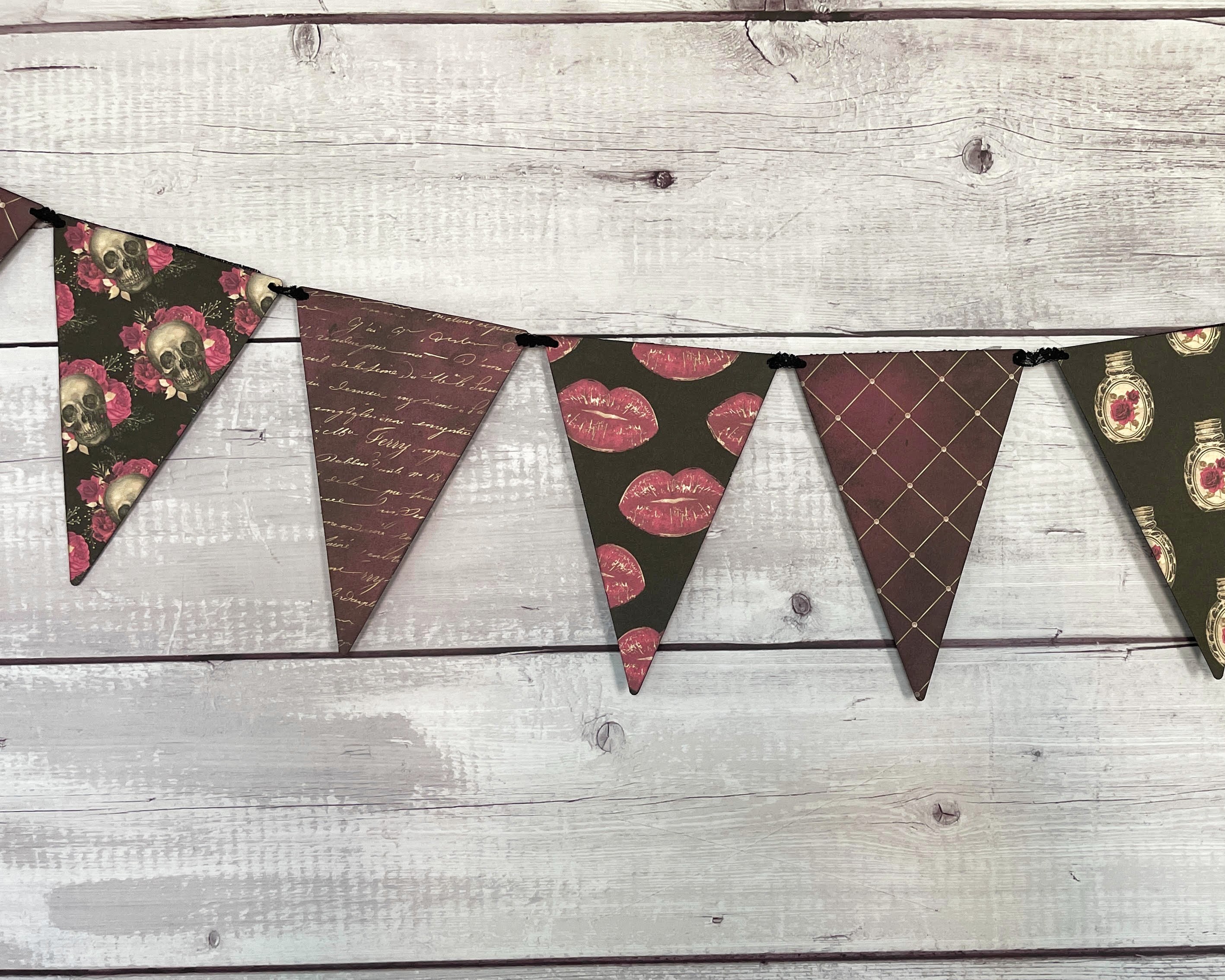 A gothic romance themed pennant banner tied with lace.  With gold, red, burgundy and black colors.