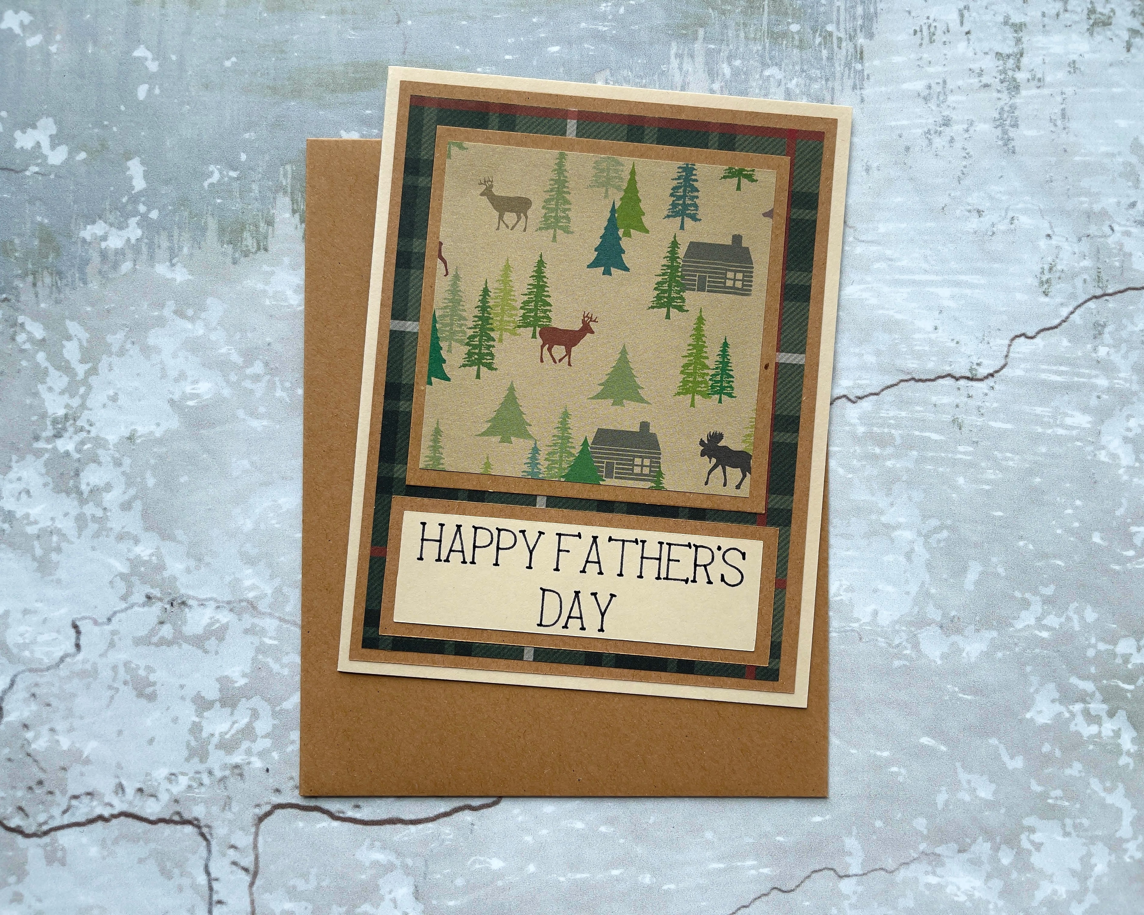 Happy Father's day card depicting a cabin in a forest with deer. 