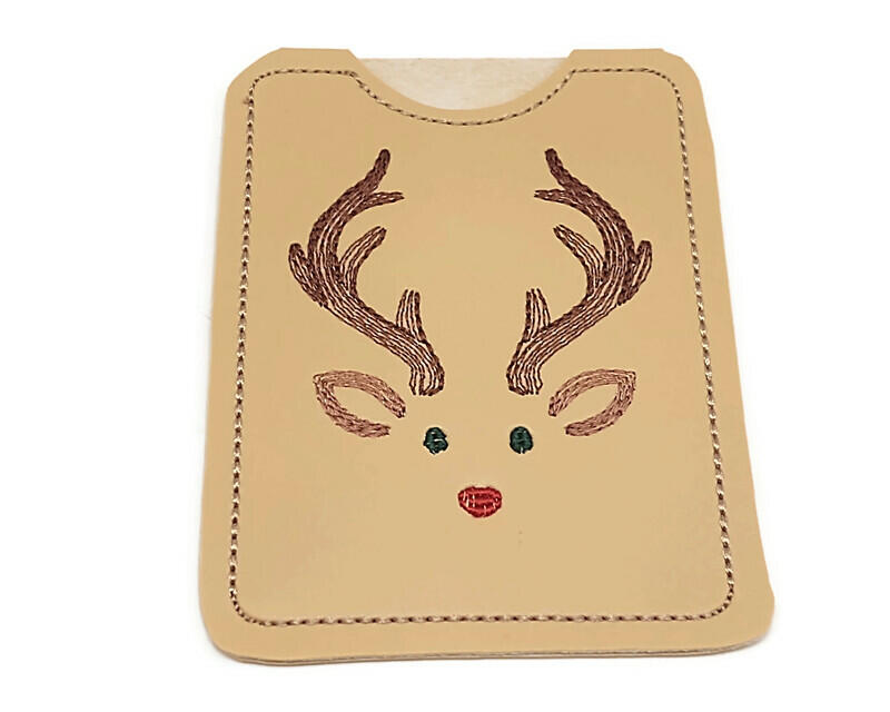 Does this little guy remind you of that famous reindeer?  He is a gift card holder and can deliver your card gift to that special person.

    What You Get:  One vinyl, machine embroidered gift card holder.  Card holder is reusable.
    Fabrics Used:   Vinyl, polyester embroidery thread and tear away stabilizer.
    Fabric color:  The vinyl is a deer tan, with dark brown antlers, light brown ears, green eyes and, of course, the red nose.  The outline is a light tan.  Each one is hand cut.
    Size:  3 1/4 x 4 1/4 inches.  Picture 3 shows size compared to my hand.
    Care:  Wipe with a damp cloth.