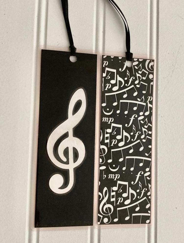 Glossy black and silver metallic combineto make a Treble Clef  double sized bookmark. Made of cardstock and laminated 
Measurents: 2.25" W x 6:" L