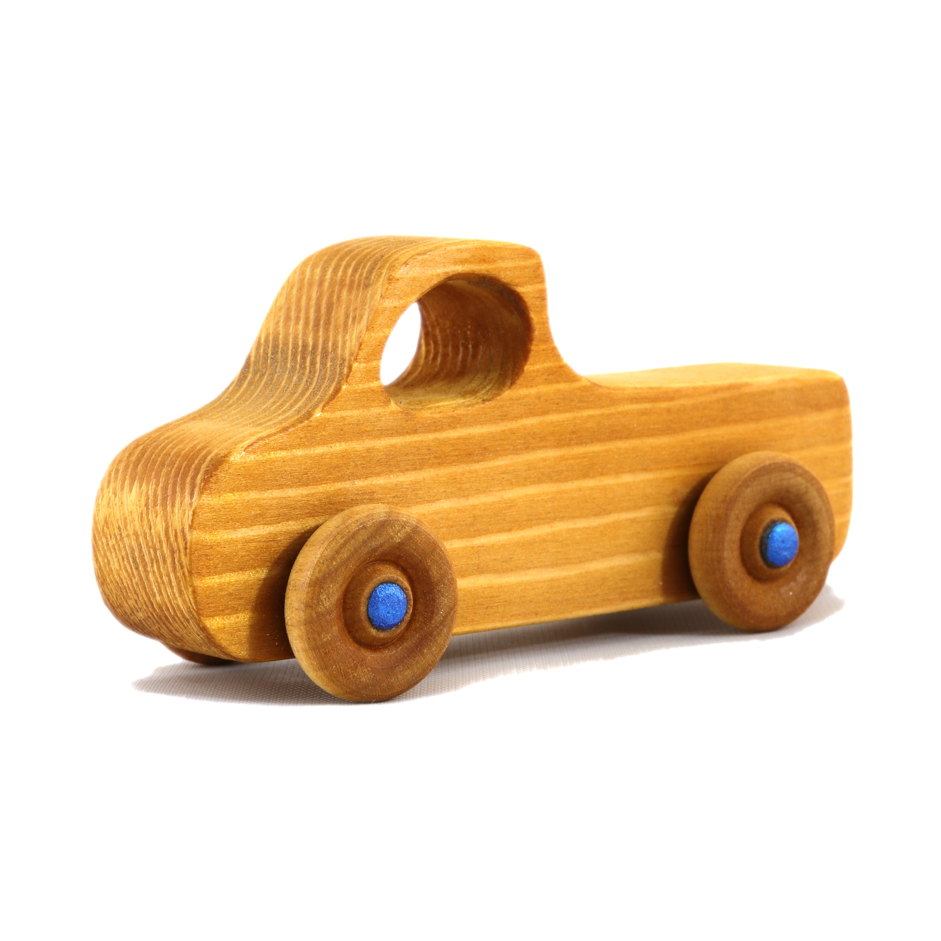 A handmade wooden pickup truck from the Play Pal Collection with an amber shellac finish and metallic sapphire blue acrylic paint.