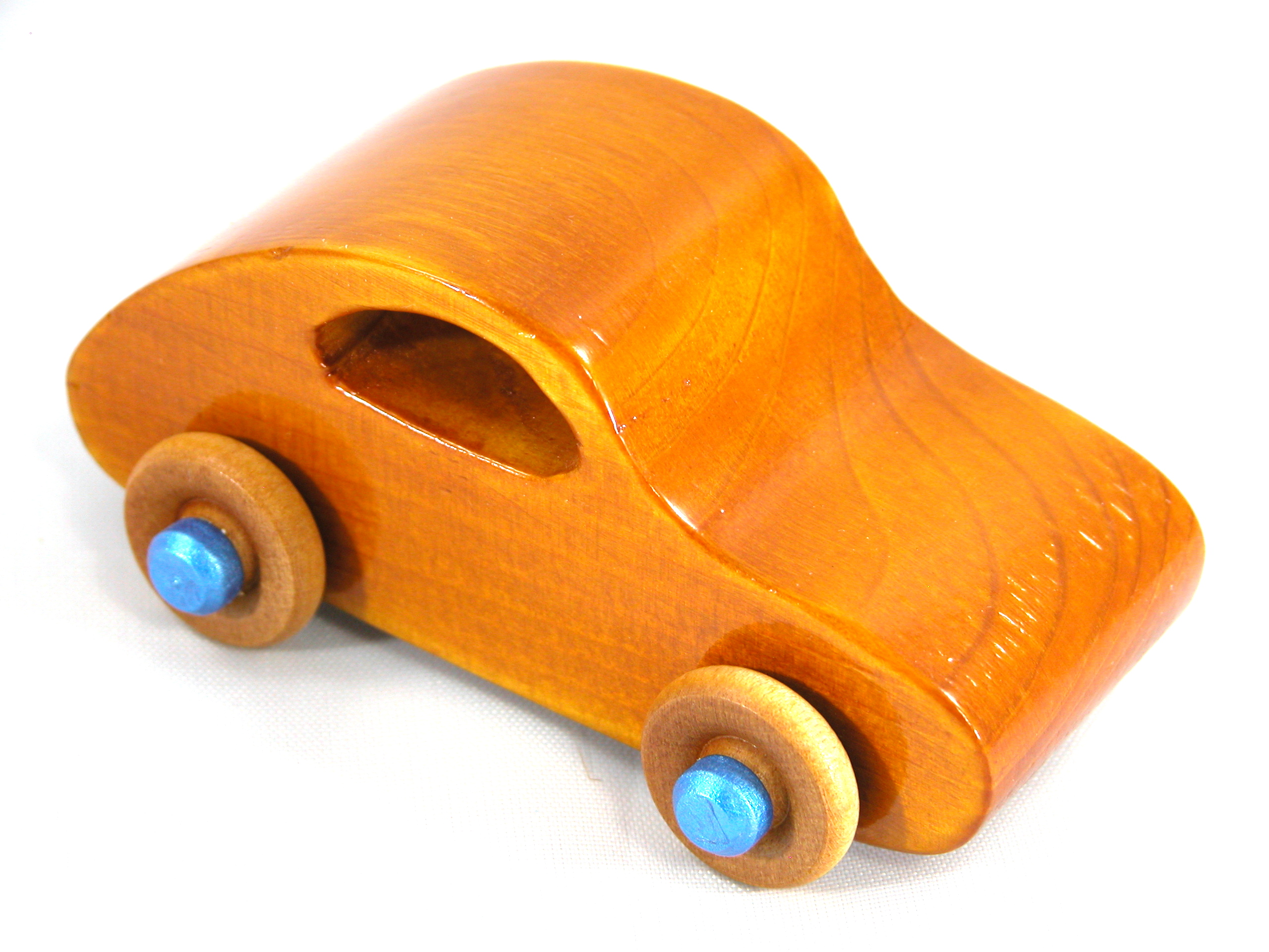 A handmade wooden toy car modeled after the iconic 1957 bug, finished with amber shellac and metallic sapphire blue trim. It's part of my Play Pal Collection.