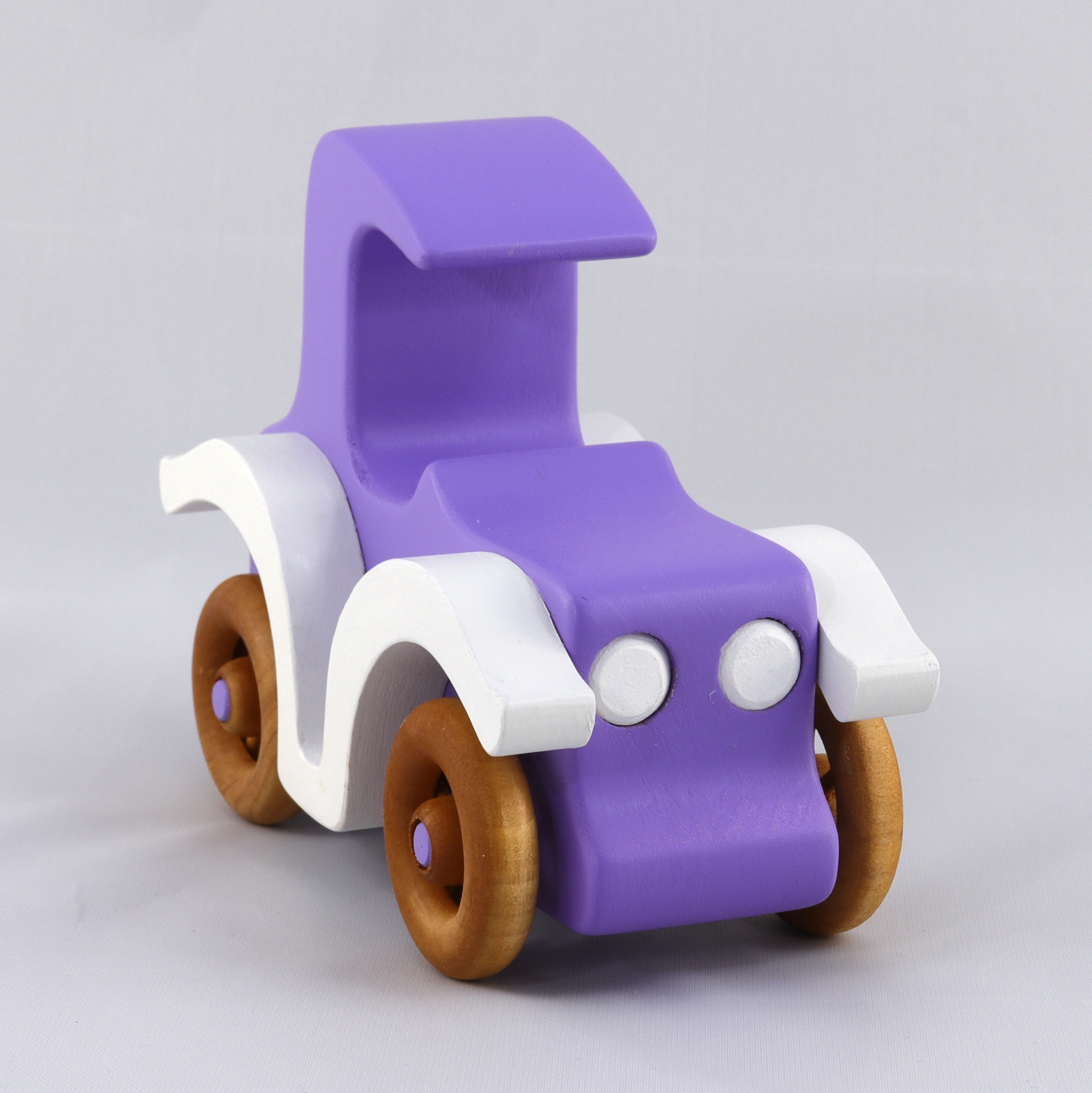 A handmade wooden toy car vintage style coupe painted nontoxic purple and white with spoked wheels finished with nonmarring amber shellac, from my  Bad Bob's Custom Motors Collection.