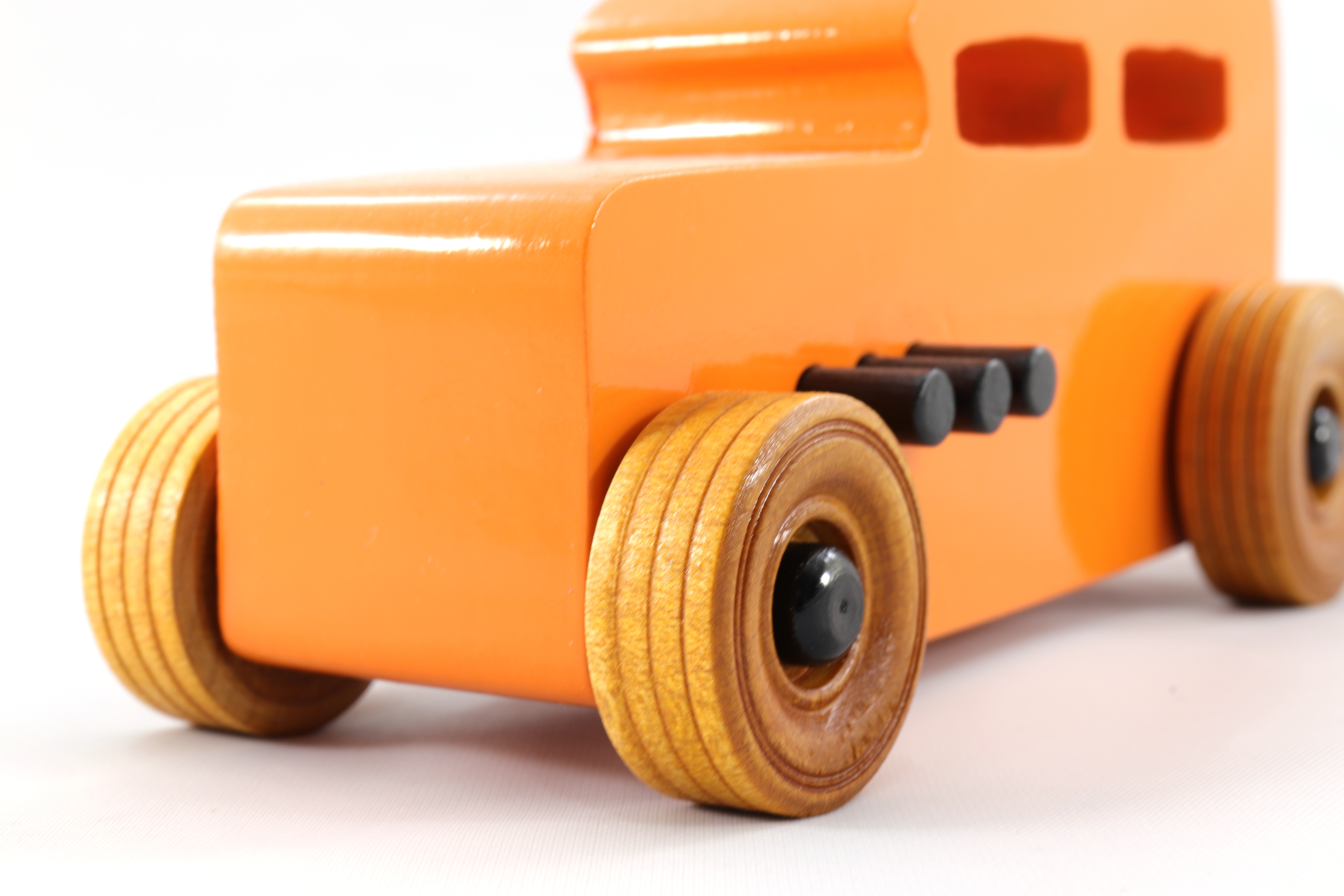 Handmade wooden toy car: hot rod '32 Sedan painted in high gloss Pumpkin Orange with black trim and non-marring amber shellac wheels.