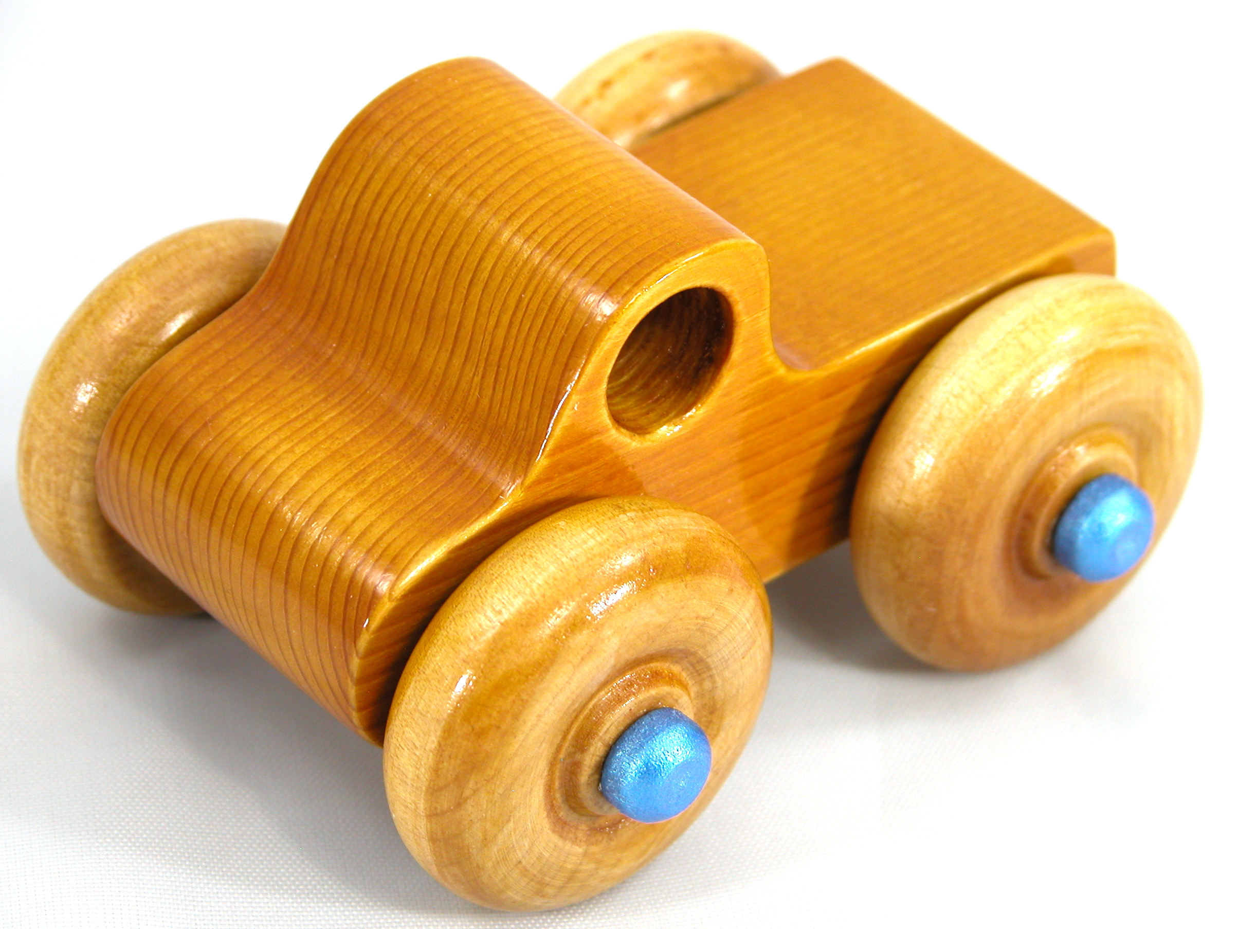 Handmade Wooden Toy Truck With Round Windows Finished with Glossy Amber Shellac and Metallic Sapphire Blue Acrylic Paint trim. Excellent, durable push toy for toddlers with chunky wheels that roll well on any surface.