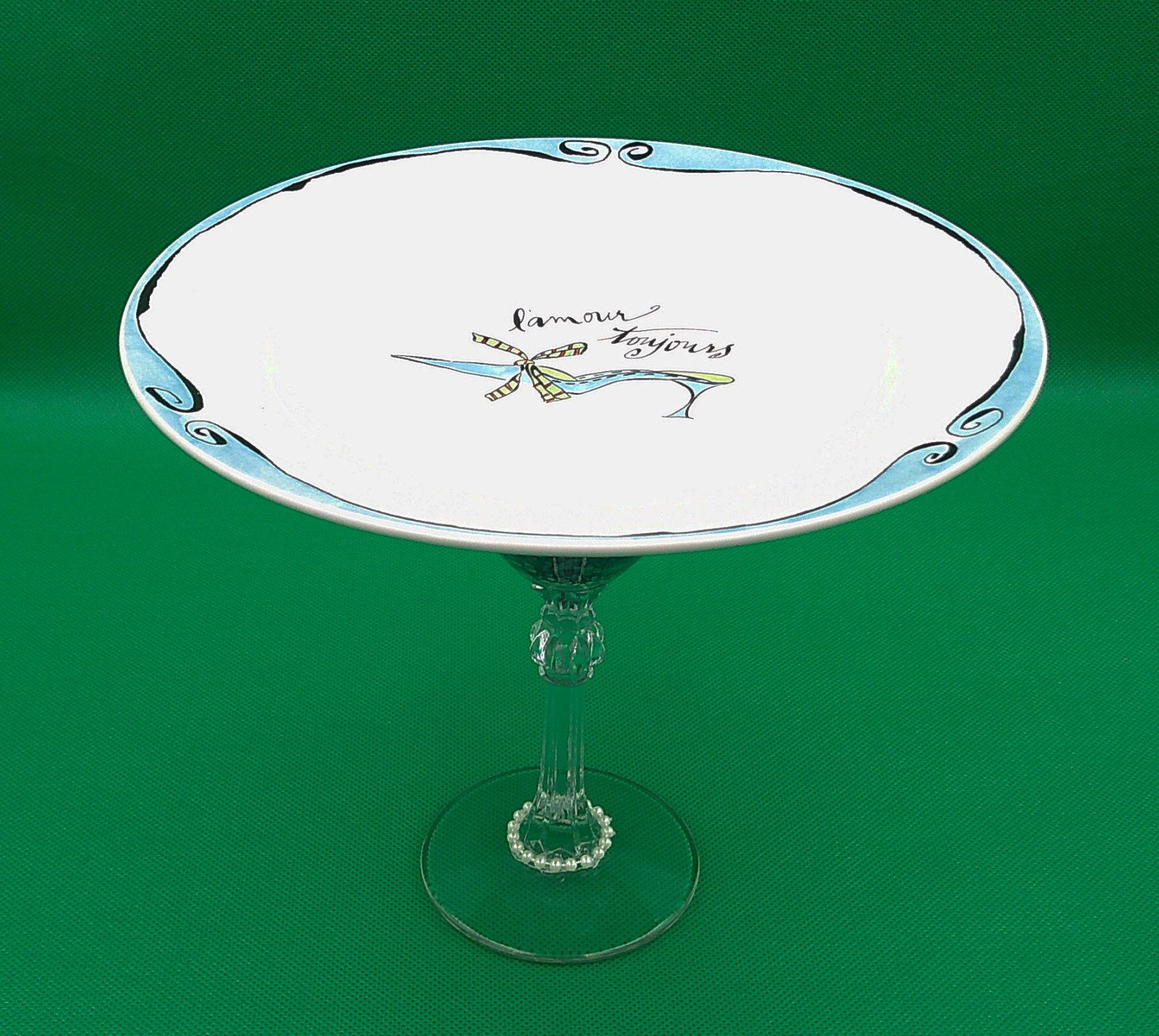 Unique one of a kind dish shows off the shoe and trim work sitting atop the martini glass filled with lace. Unique one of a kind dish shows off the shoe and trim work sitting atop the martini glass filled with lace.