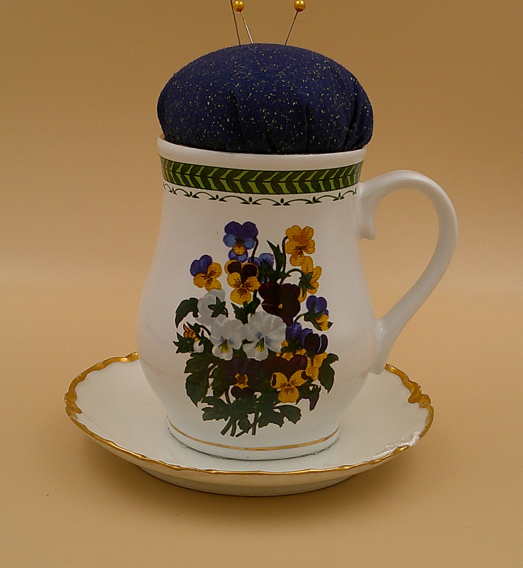 This is a front view of the pincushion attached to the saucer. It clearly shows the vibrancy of the bouquet of pansies. This is a front view of the pincushion attached to the saucer. It clearly shows the vibrancy of the bouquet of pansies.