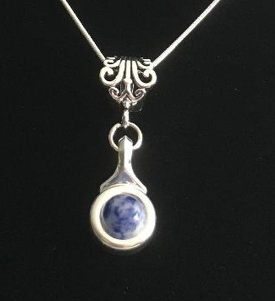 Beautiful Blue Jasper stone is viewed on a flute trill key.  A fleur de lis bail on a  16" silver plated snake chain.  Available in 10 stone choices that include s: coral, pastel green, pastel, pink ande more. Lovely small silver pendant that is wearable for leisure or dress.
