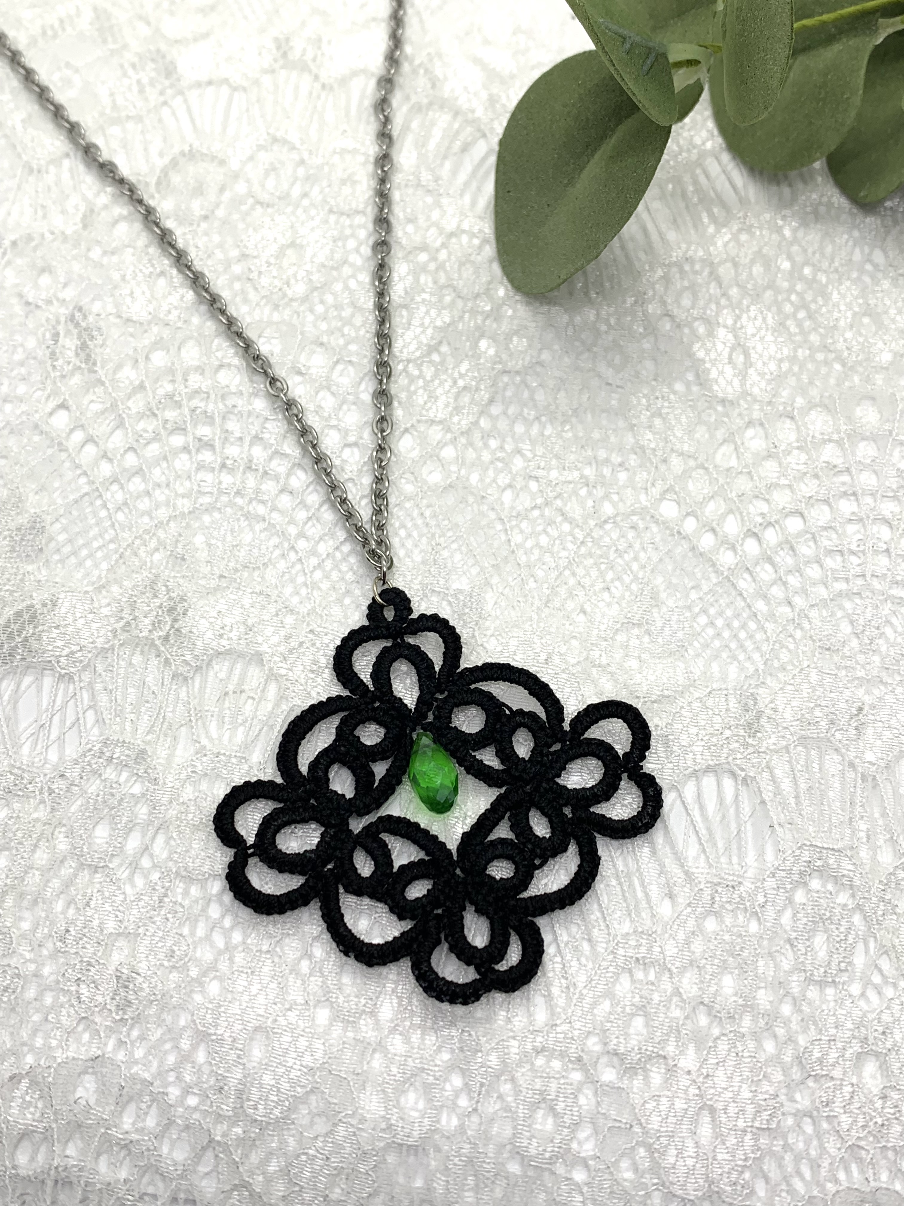 Black lace pendant with faceted green crystal