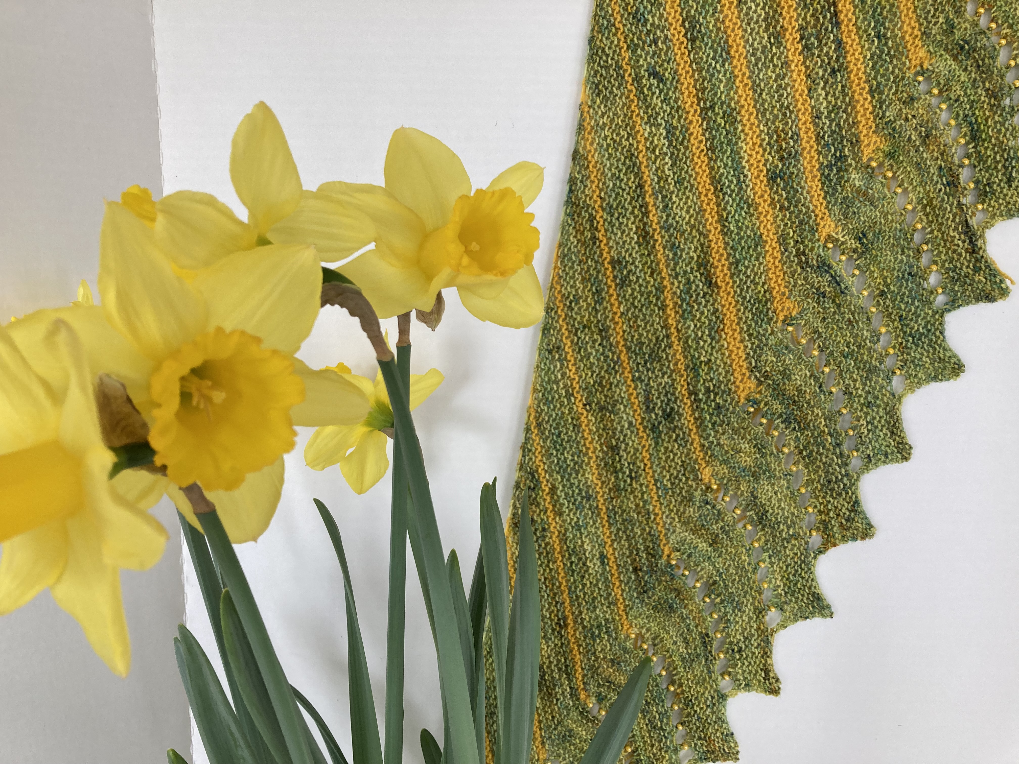 Green and yellow hand knit shawl with daffodils